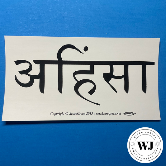 Sticker with black Sanskrit script saying “Ahimsa” on a white background