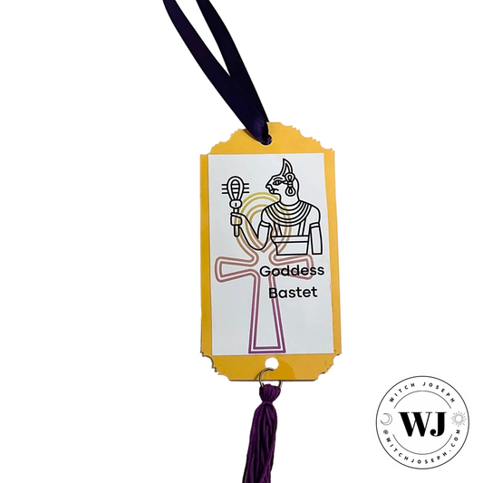 Decorative tag with illustration of Goddess Bastet and purple tassel on white background