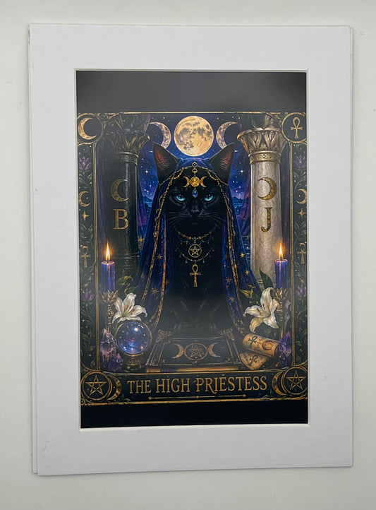 A matted art print featuring a dark, mystical tarot card illustration titled 'THE HIGH PRIESTESS'. The artwork depicts a black cat in a hood with gold symbols, flanked by candles, a crystal ball, and celestial symbols under a full moon, presented in a white mat.