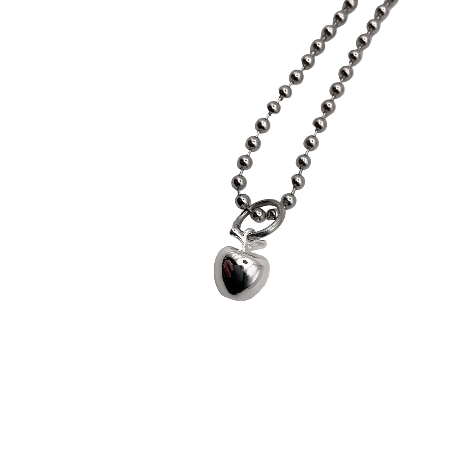 Silver tone necklace with an apple pendant on a white background.
