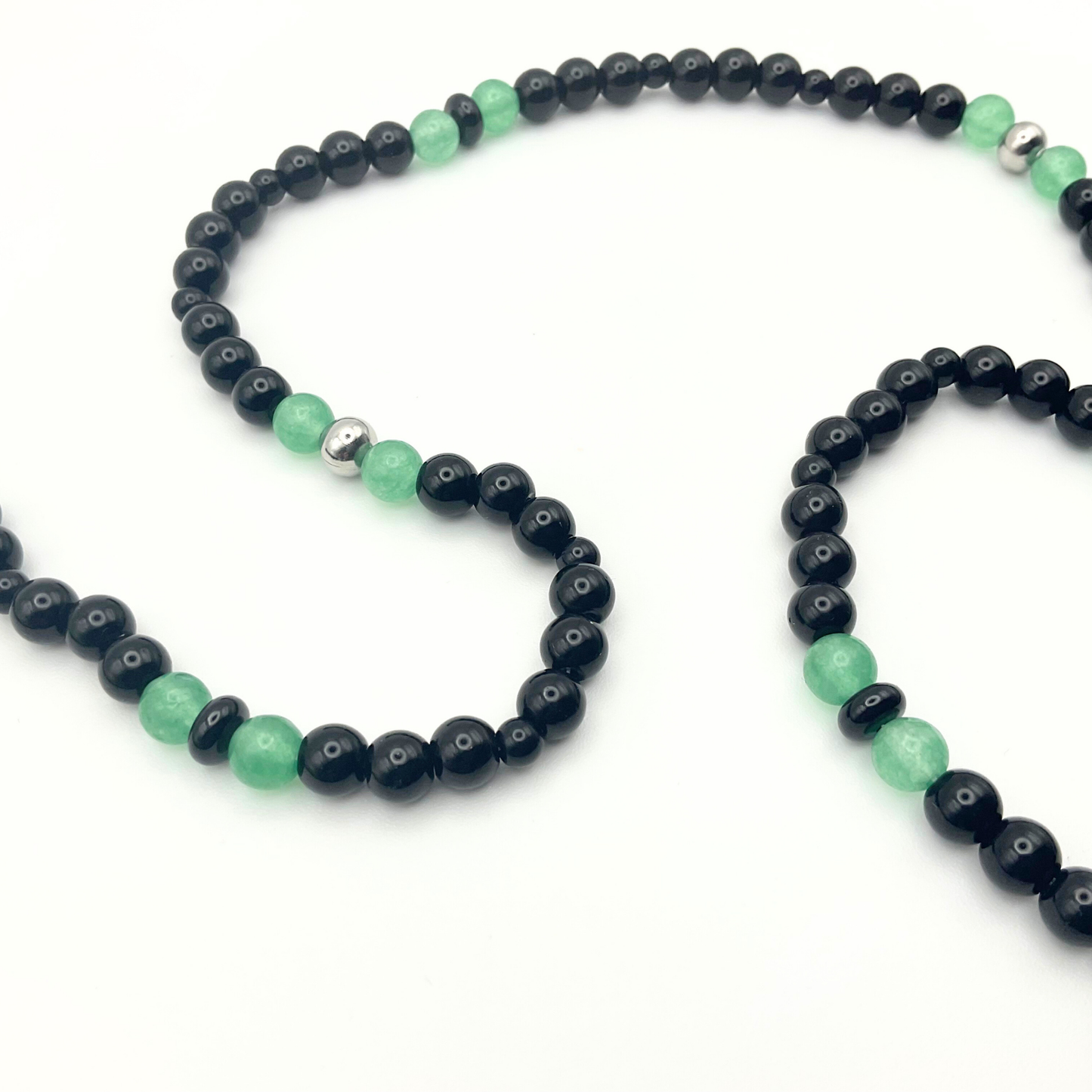 Green Aventurine Necklace with black and steel accent beads against a white backdrop.