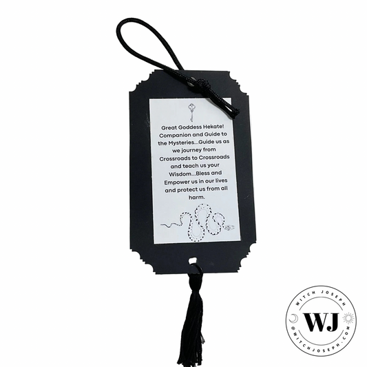 Black prayer card to Hekate with tassel on a white background, featuring the brand 'WJ'.