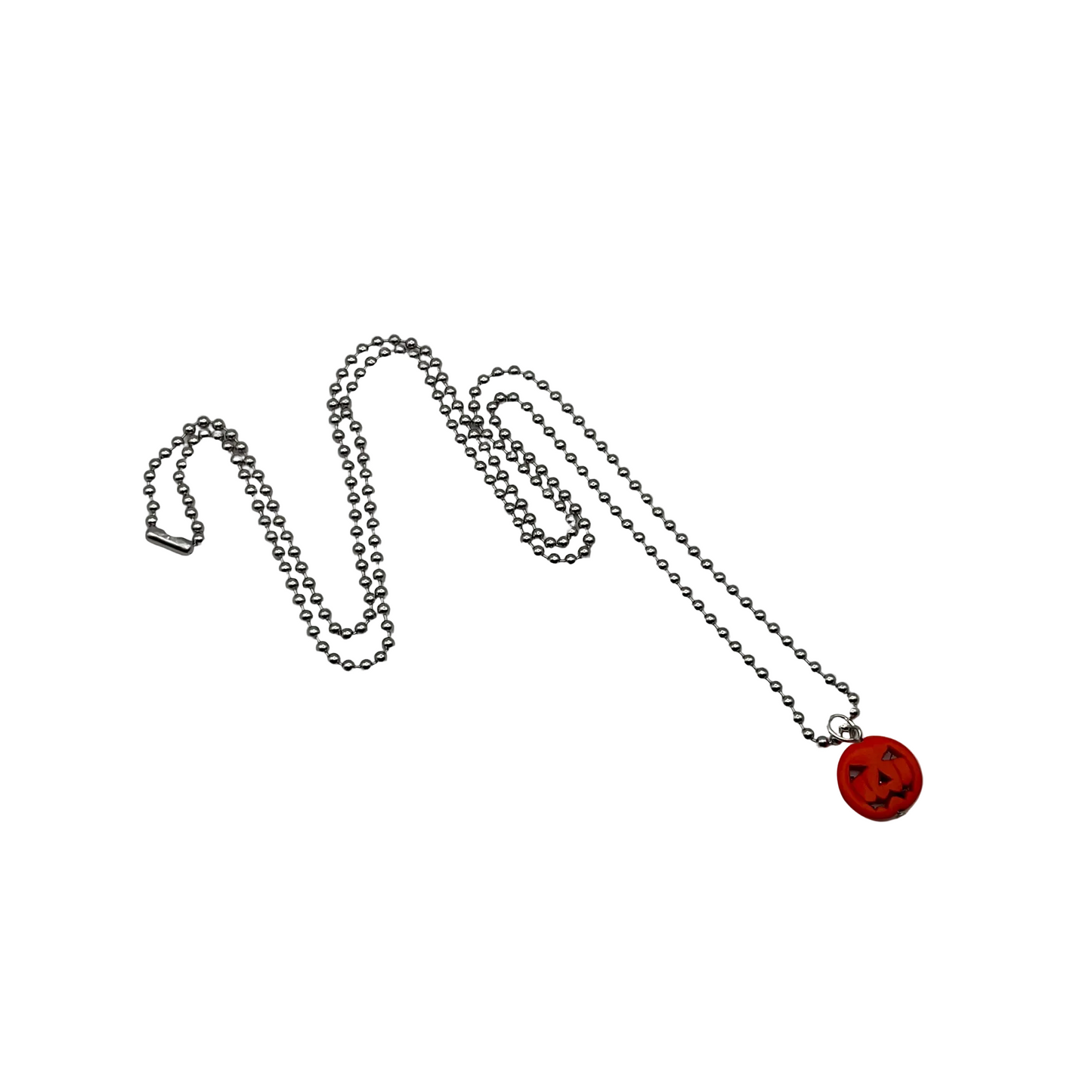 Necklace with an orange jack-o-lantern pendant on a silver tone ball chain on a white background