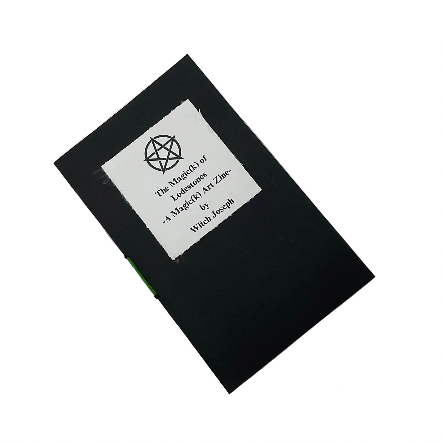 Black Zine cover with a white label with text that says “The Magick of Lodestones A Magick Zine by Witch Joseph” displayed on a white background