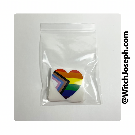 Heart-shaped rainbow flag stickers in a clear plastic bag on a white background