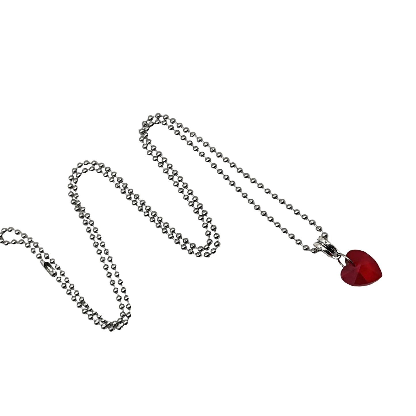 Silver tone ball chain charm necklace with a red heart crystal pendant on a white background