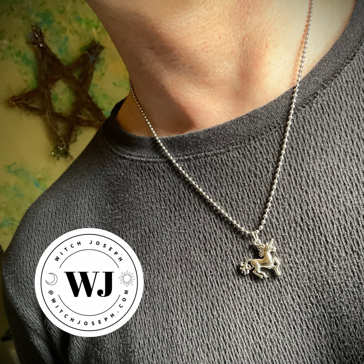 Necklace with a unicorn pendant worn by a person, with 'WJ' logo in the corner.