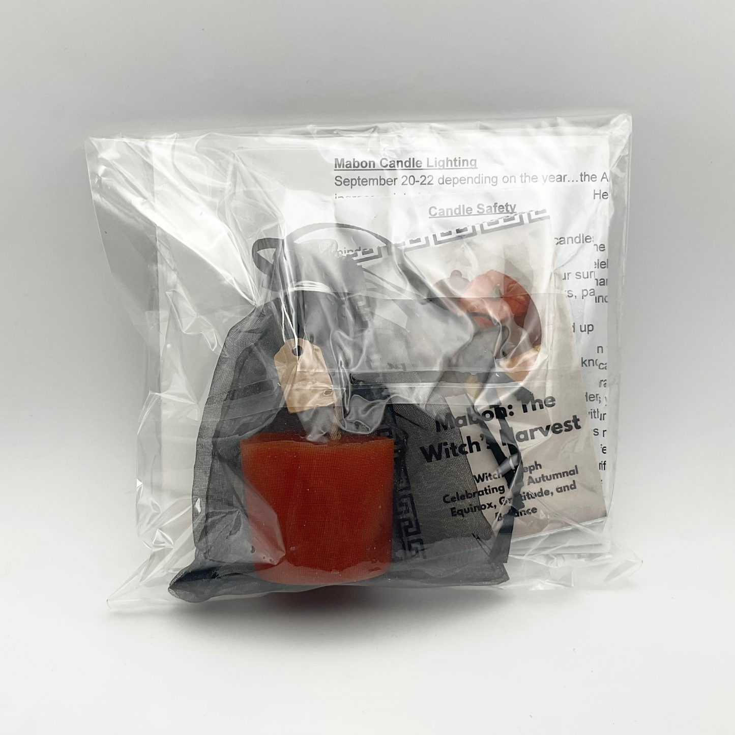 Mabon Candle and zine along with instructions seen from the transparent side of the package