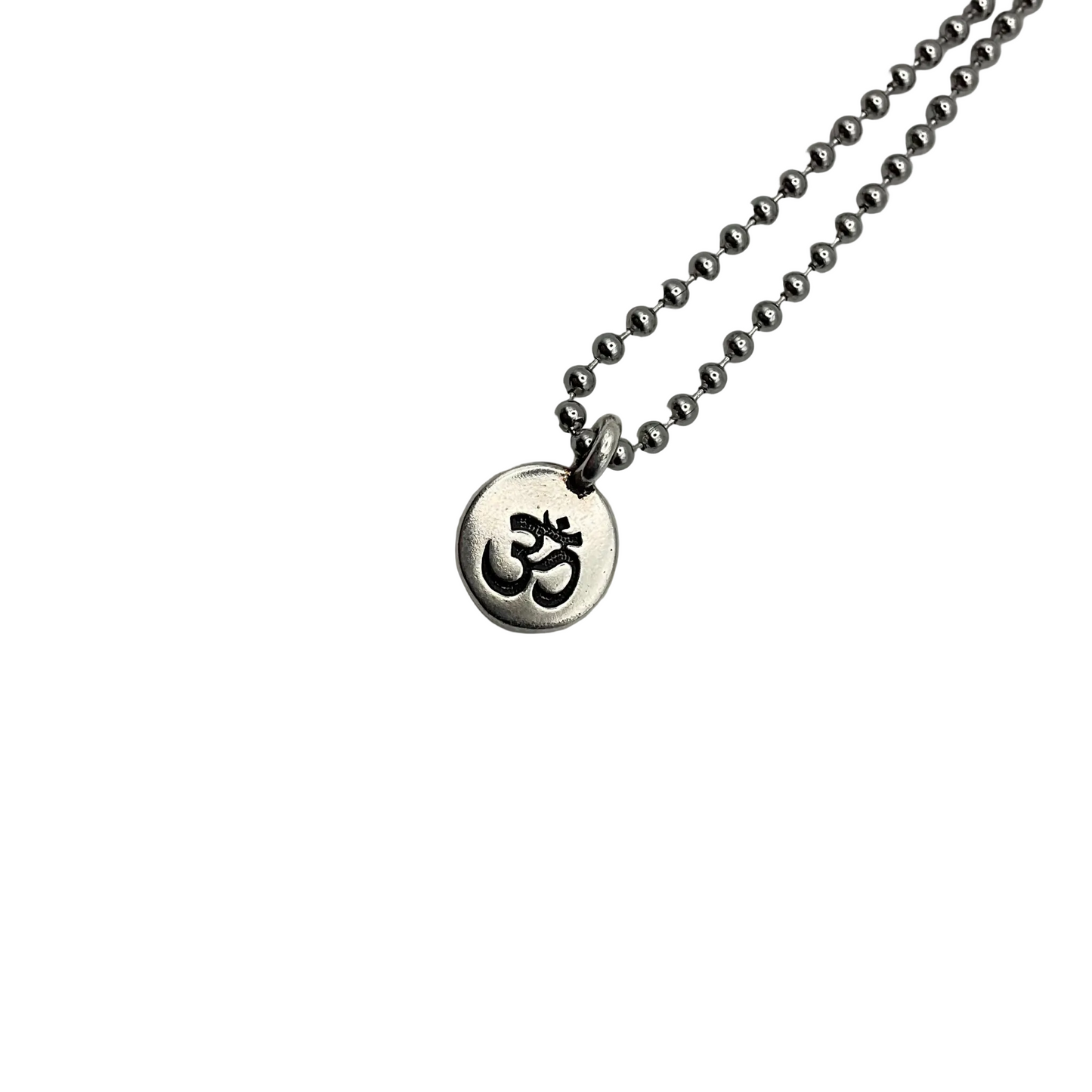 Necklace with a round pendant featuring an Om symbol on a silver tone ball chain on a white background