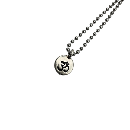 Necklace with a round pendant featuring an Om symbol on a silver tone ball chain on a white background