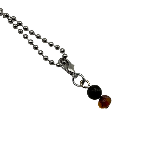 Necklace with a black and amber bead charm on a ball chain displayed on a white background