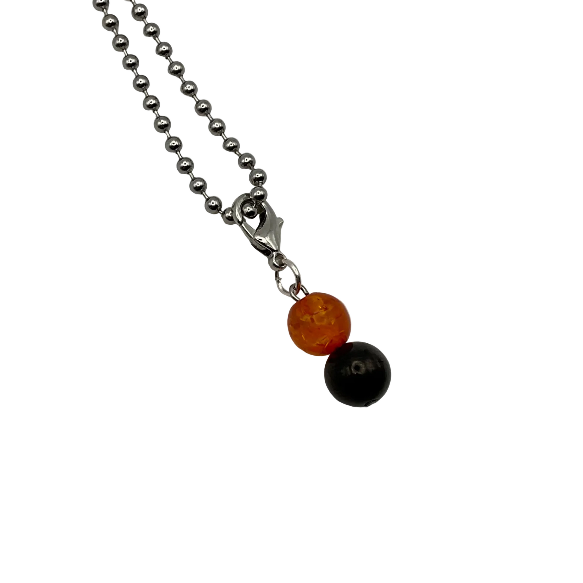 Necklace with orange amber and black jet beads large charm on a white background
