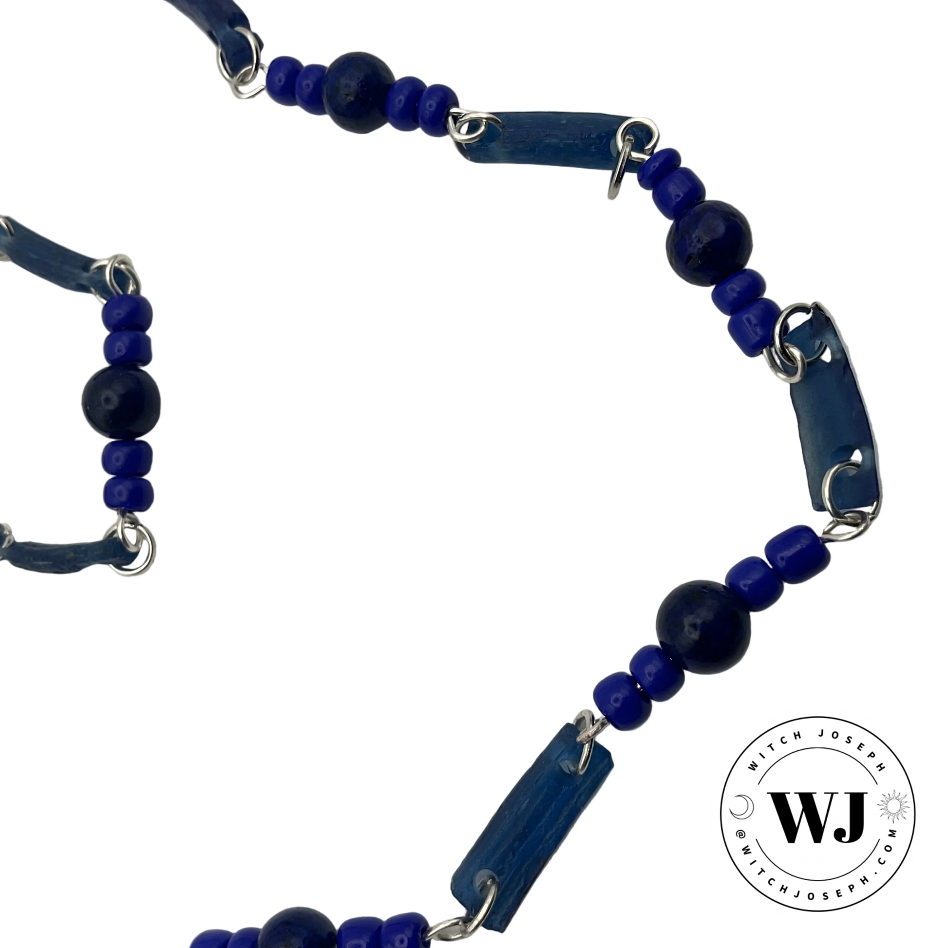 Necklace with ancient Roman glass blue beads, lapis beads and contemporary seed beads and silver tone metal links displayed on a white background with the Witch Joseph Logo