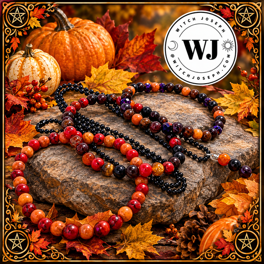 A set of Three Autumnal beaded stretch bracelets displayed on a rock surrounded by autumn leaves, pumpkins, and pinecones. The ball chain necklace features glossy black, purple and orange beads, and the other features round beads in red, orange…with the Witch Joseph logo in the picture.
