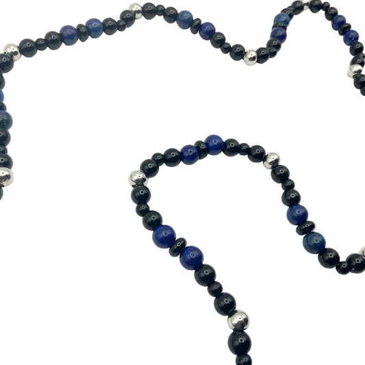 blue lapis lazuli necklace with black and steel bead accents against a white background.