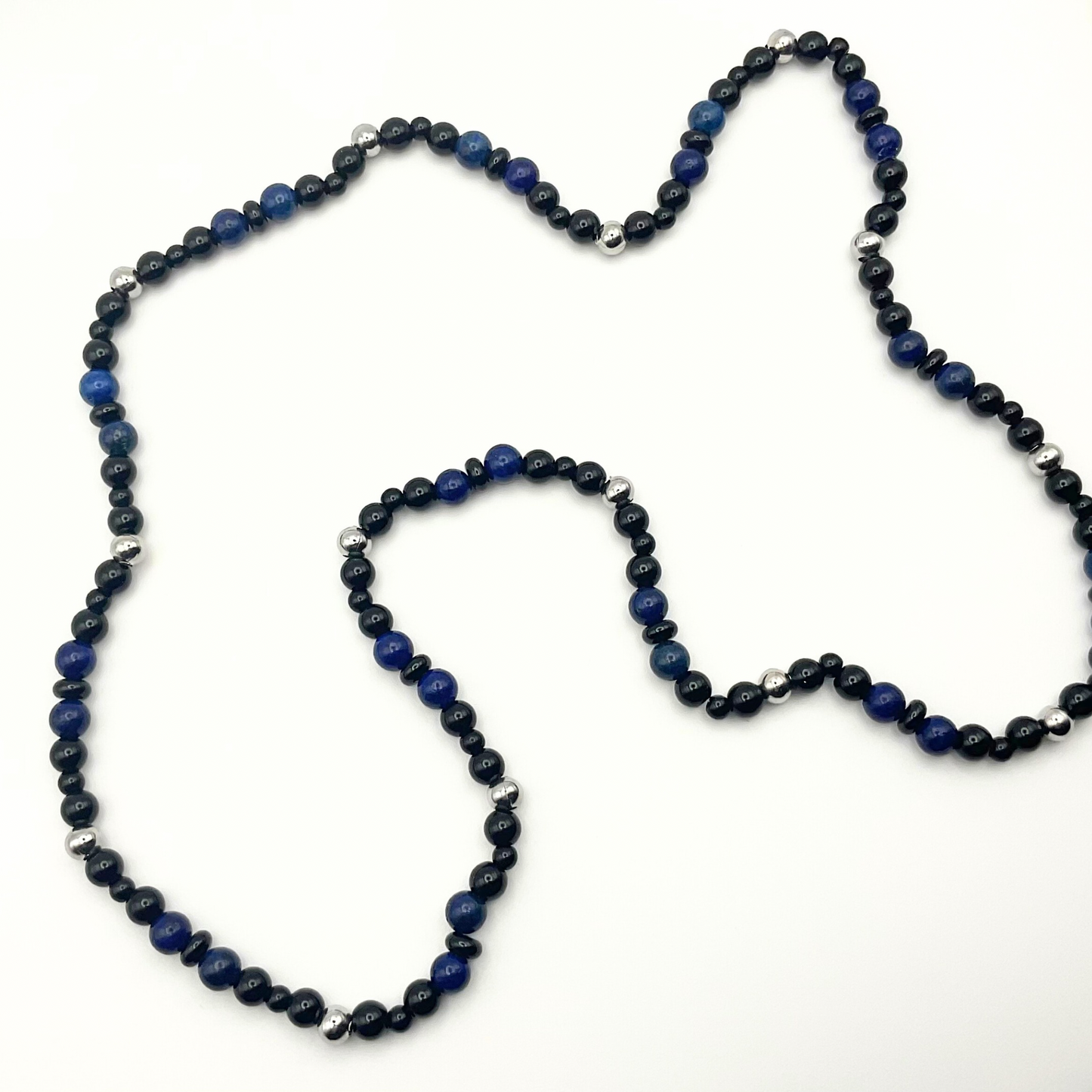 Blue Lapis Lazuli beaded necklace with black and steel bead accents against a white background.