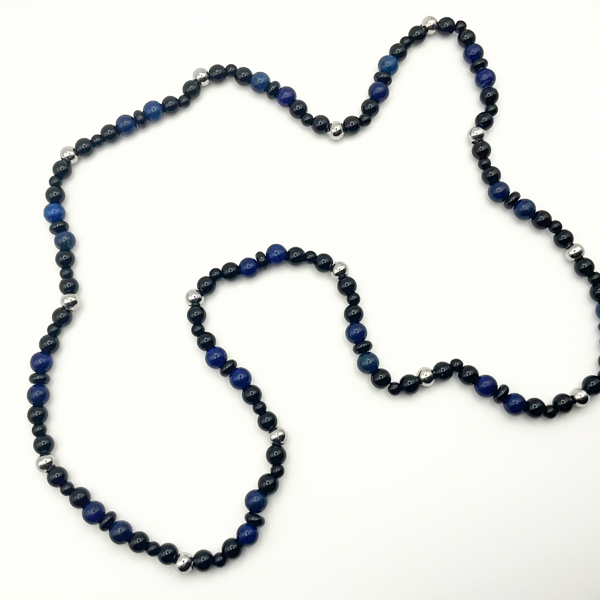 Blue Lapis Lazuli beaded necklace with black and steel bead accents against a white background.