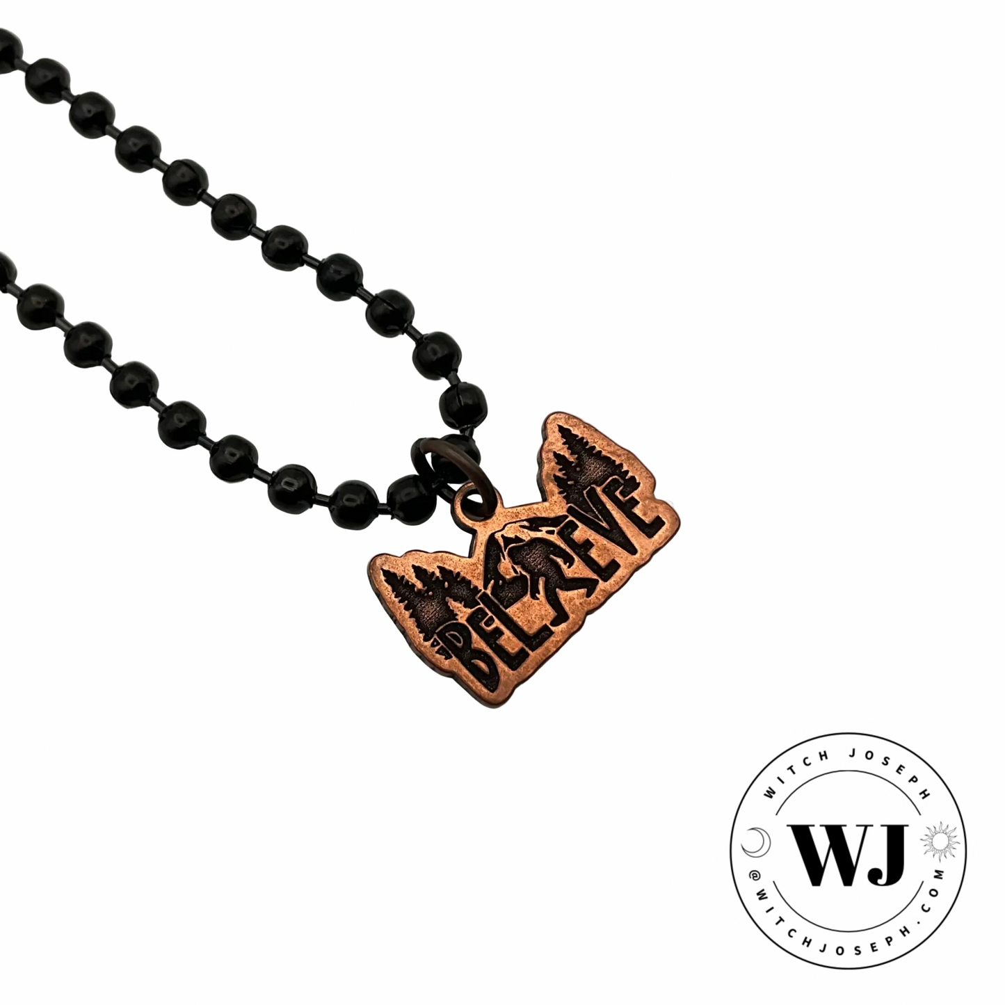 the Bigfoot copper charm necklace…pendant shows an etching of Bigfoot against a backdrop of trees and mountain…displayed against a white background with the Witch Joseph logo