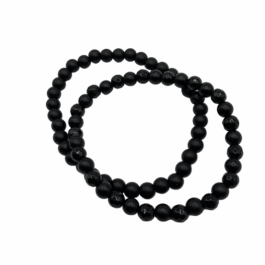 Two black beaded bracelets displayed on a white background