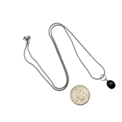 Silver tone necklace with a black pearl pendant on a white background
