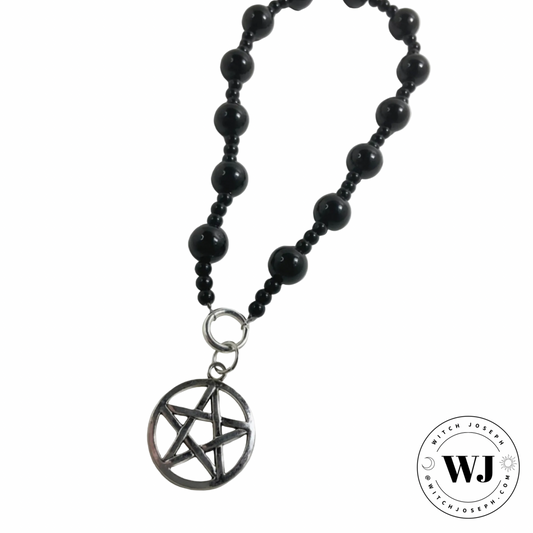 Black beaded prayer beads with a pentagram pendant displayed on a white background, featuring the brand 'WJ'.
