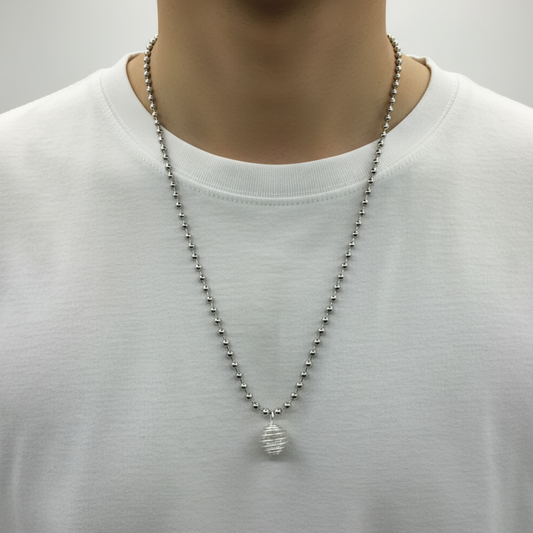 Person wearing a silver tone celestite chip cage necklace on a plain background