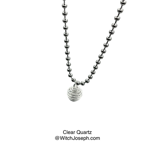 Silver tone ball chain necklace with a clear quartz chip in cage pendant on a gray background