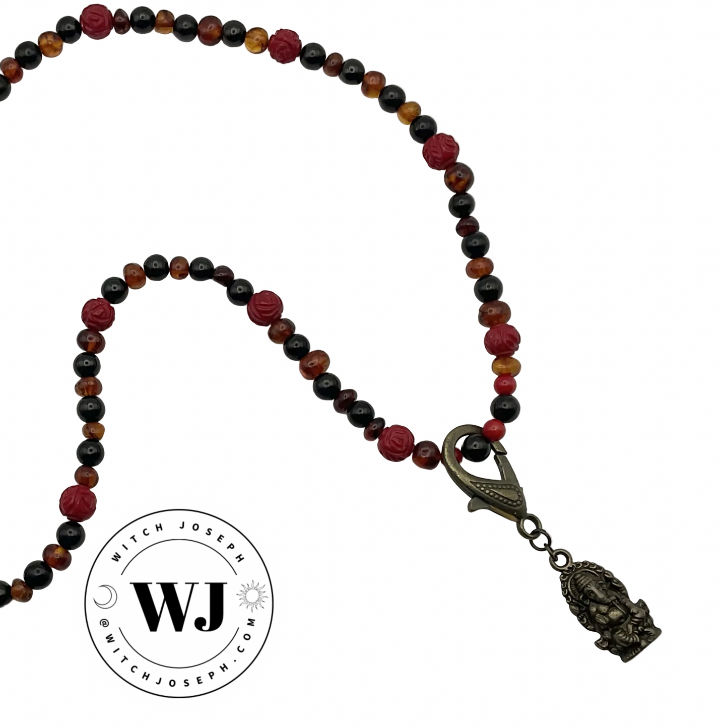 Lord Ganesha Talisman with brass tone pendant and findings with rose coral beads and Baltic amber with Russian jet beads displayed against a white background with the Witch Joseph Logo