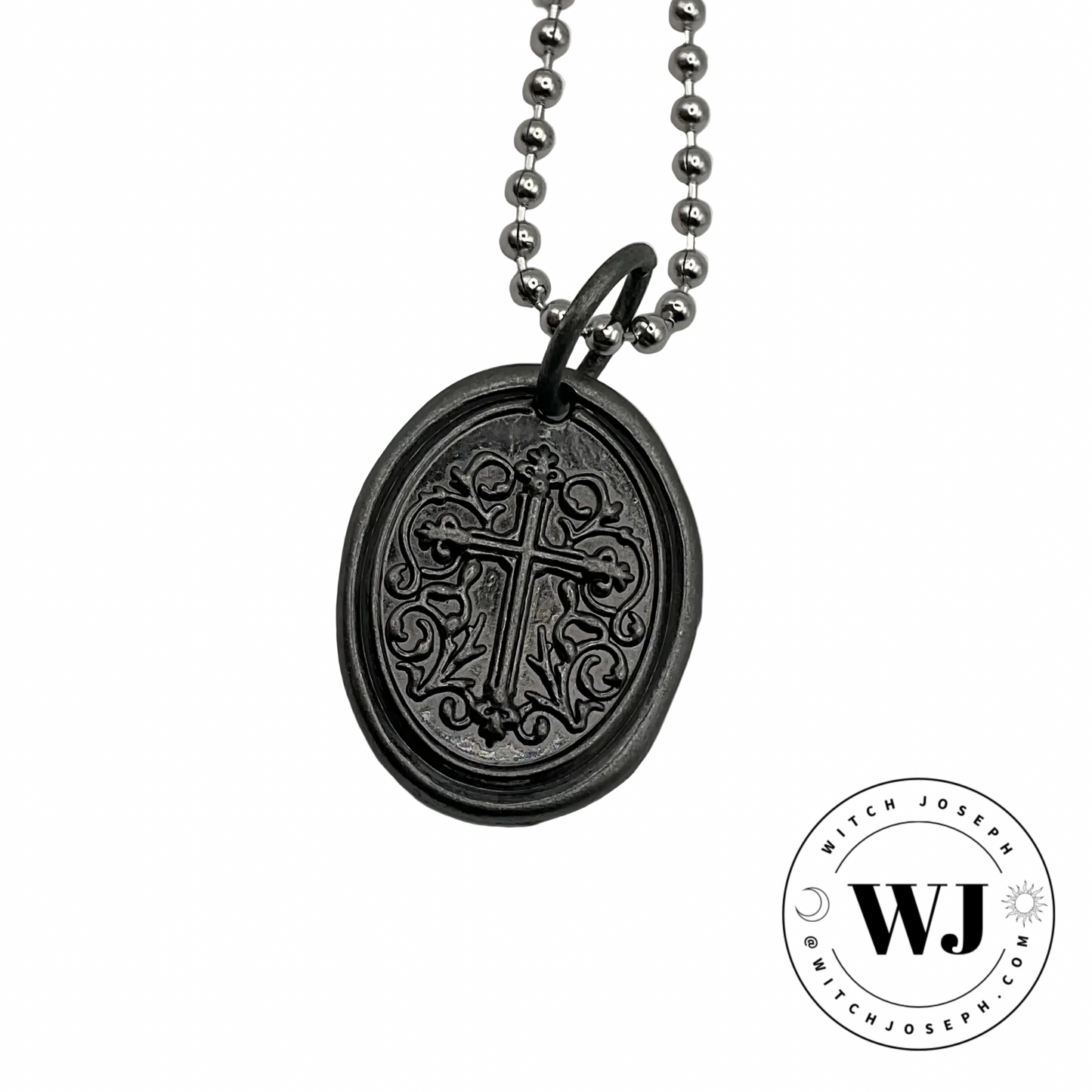 Gunmetal oval cross pendant on silver tone ball chain with intricate design displayed on a white background, featuring the Witch Joseph logo