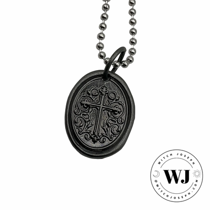 Gunmetal oval cross pendant on silver tone ball chain with intricate design displayed on a white background, featuring the Witch Joseph logo