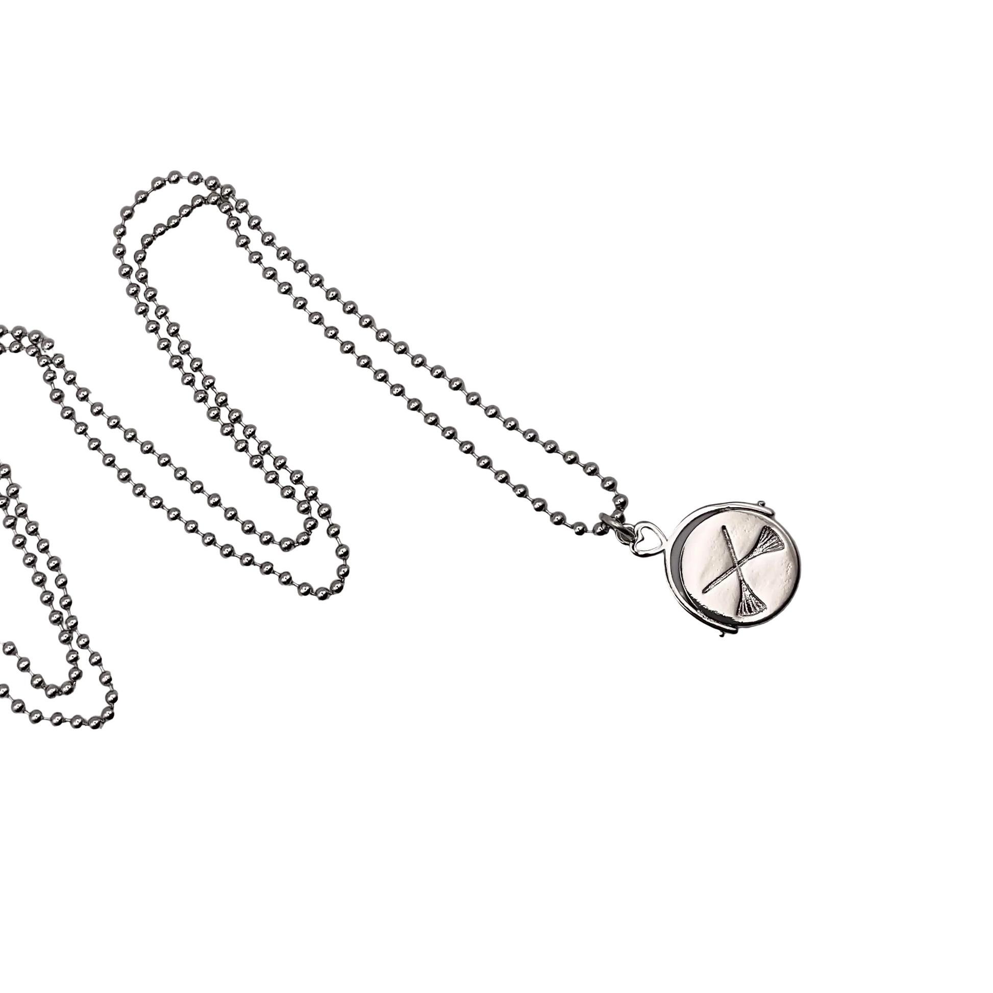 Necklace with a circular pendant featuring a crossed brooms design and on the reverse a Witch Hat design on a white background.