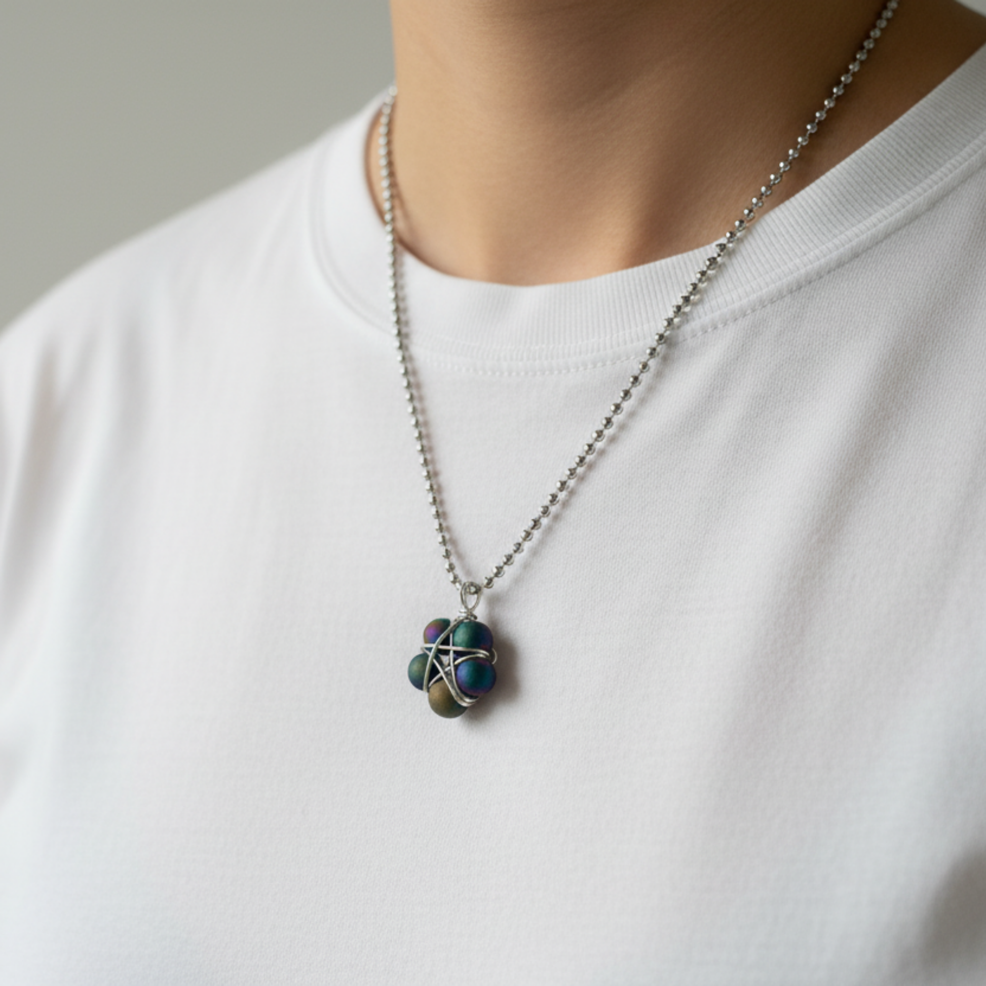 Ball chain Necklace with a druzy bead wire wrap pentagram pendant worn by a person on a plain background