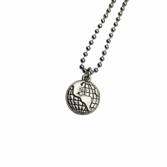 Silver tone necklace with an earth globe pendant on a white background