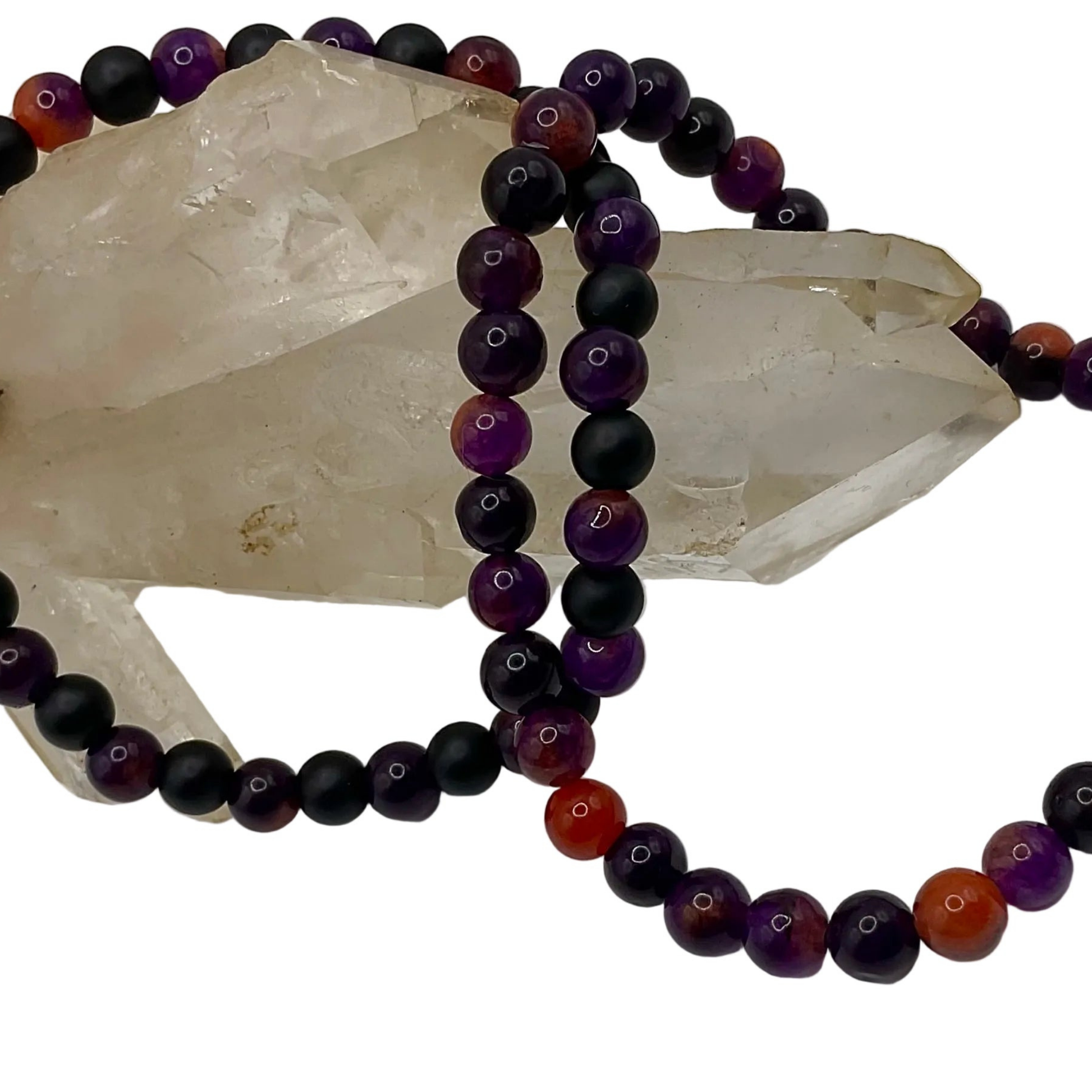 Beaded necklace with black, purple, and orange beads displayed on a crystal against a white background