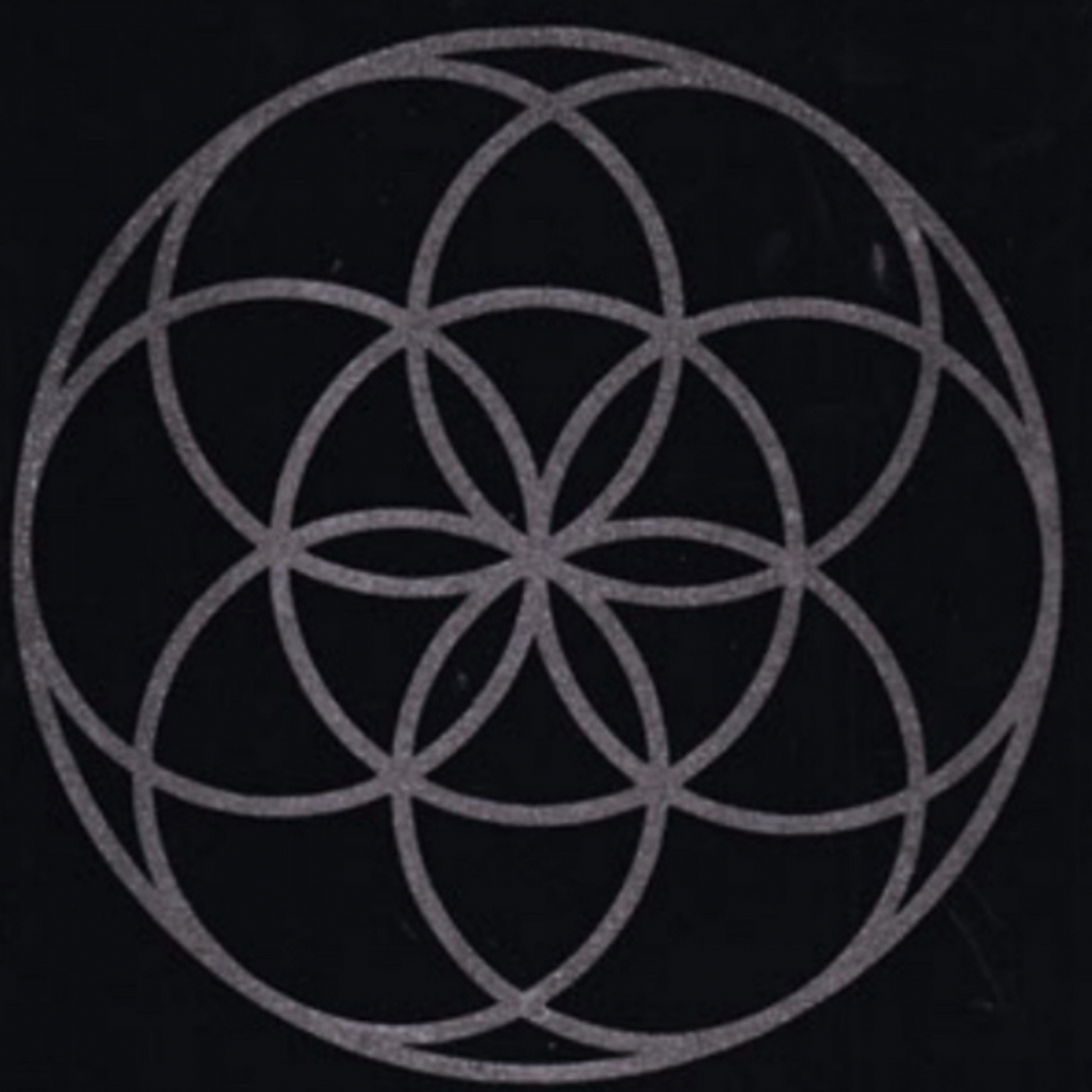 Geometric flower of life design of interlocking circles on a black background mat
