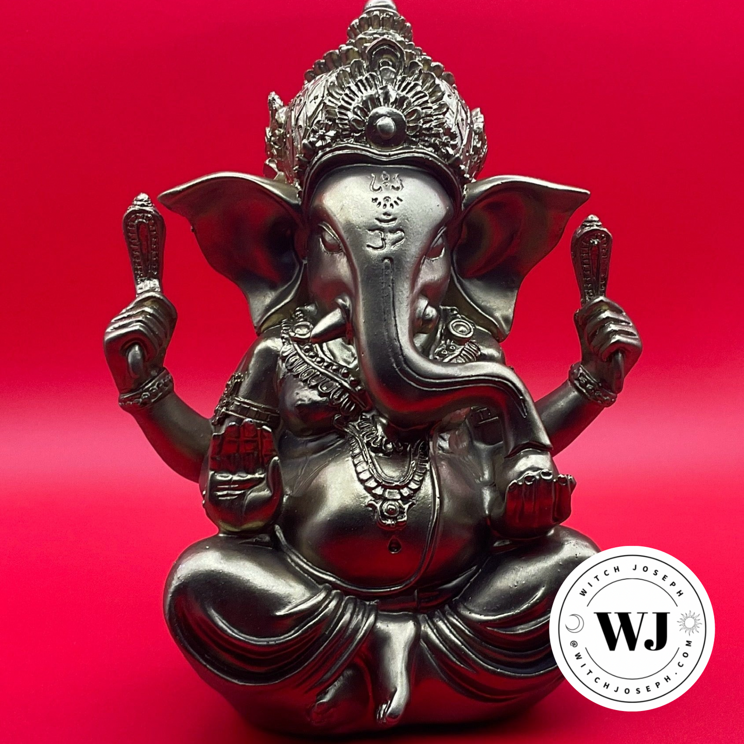 Gold statue of Ganesha on a red background with 'WJ' Witch Joseph logo.