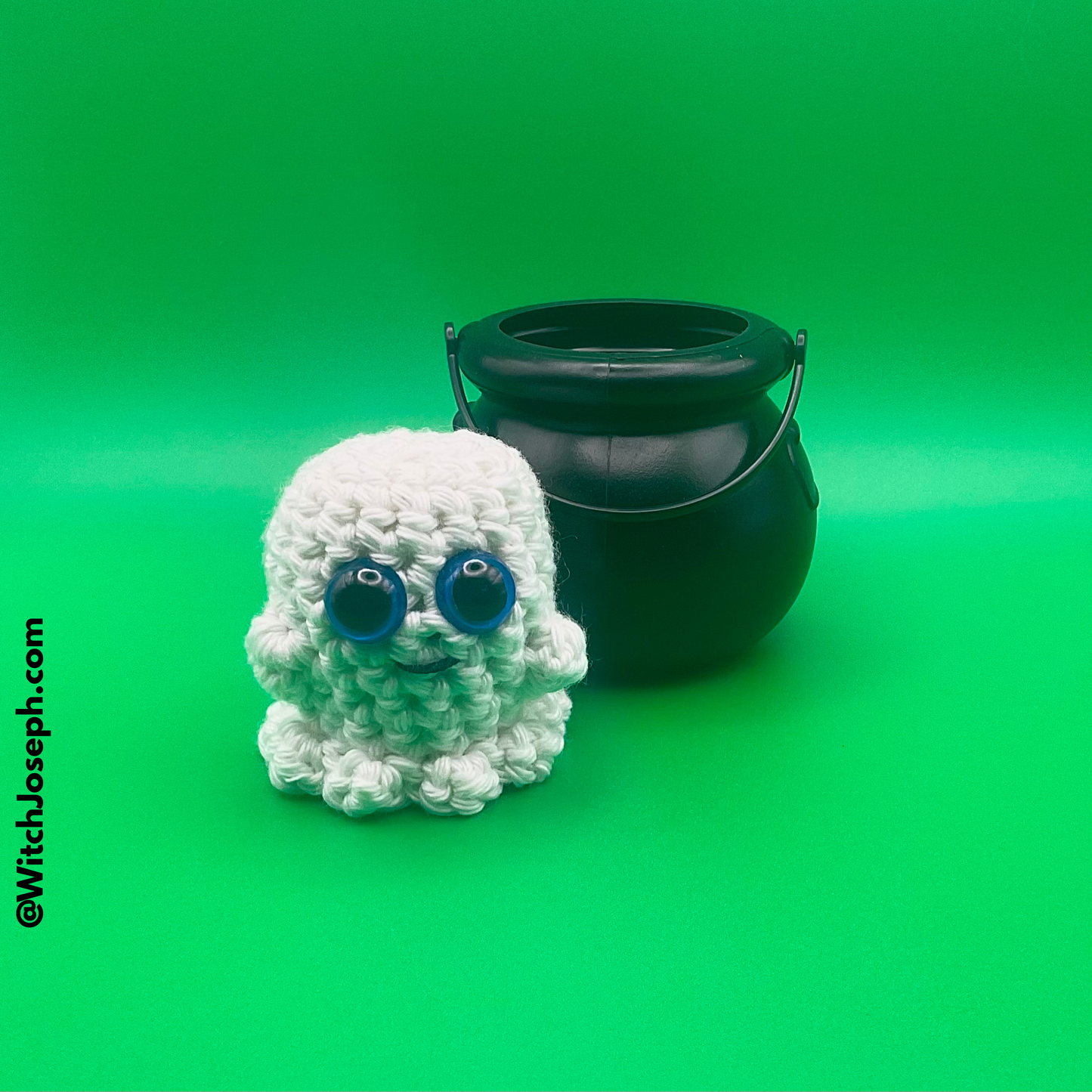 White crochet ghost with blue eyes and a black cauldron on a green background with the Witch Joseph URL