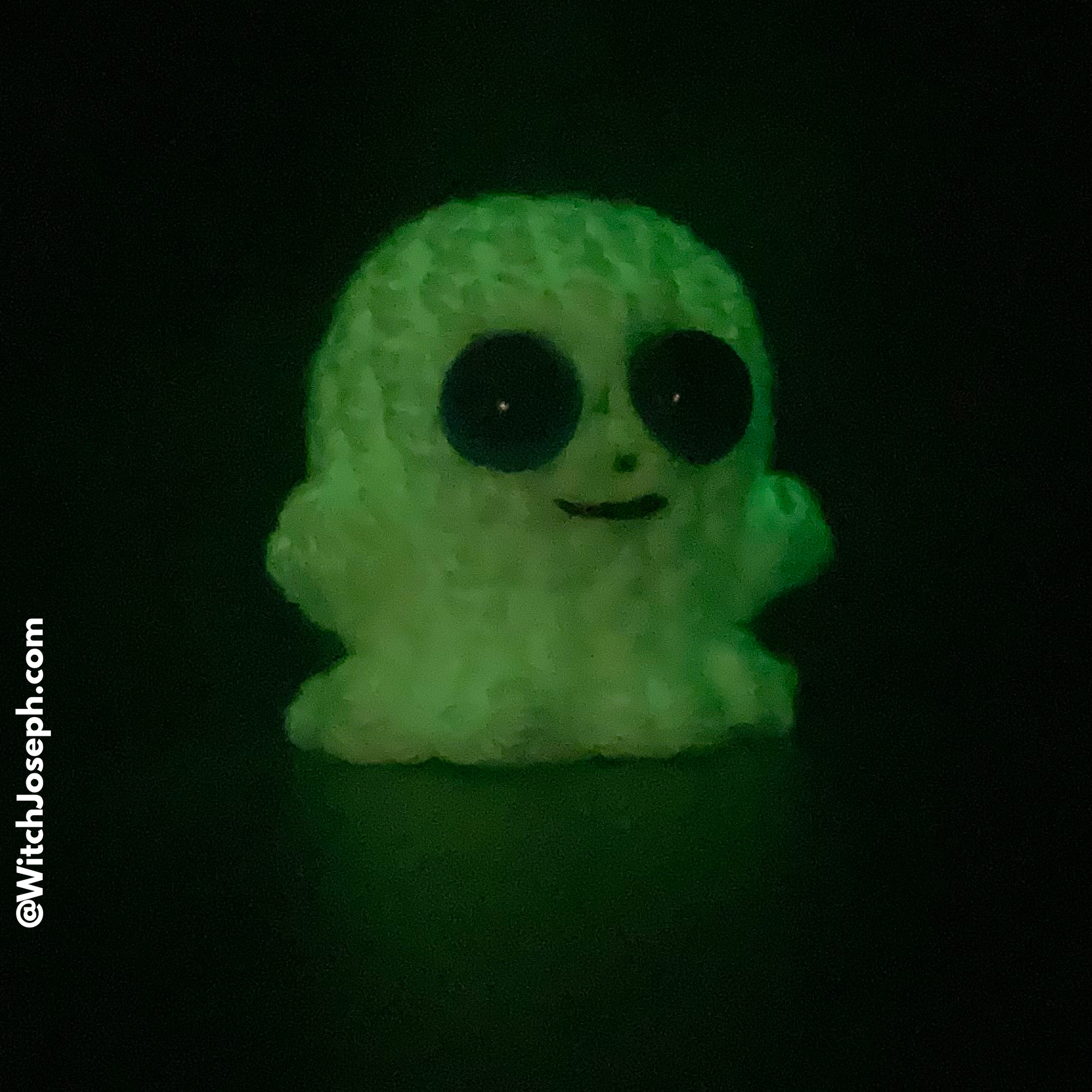 Glowing green ghost figurine on a black background with the Witch Joseph URL