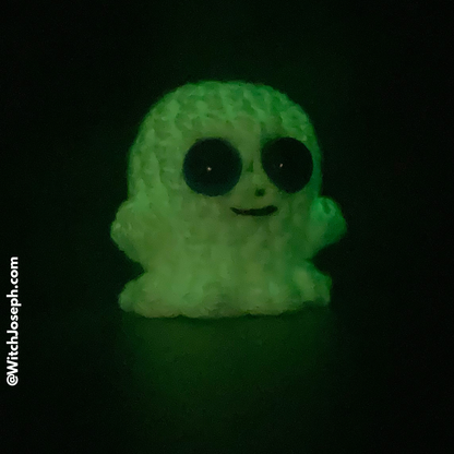 Glowing green ghost figurine on a black background with the Witch Joseph URL