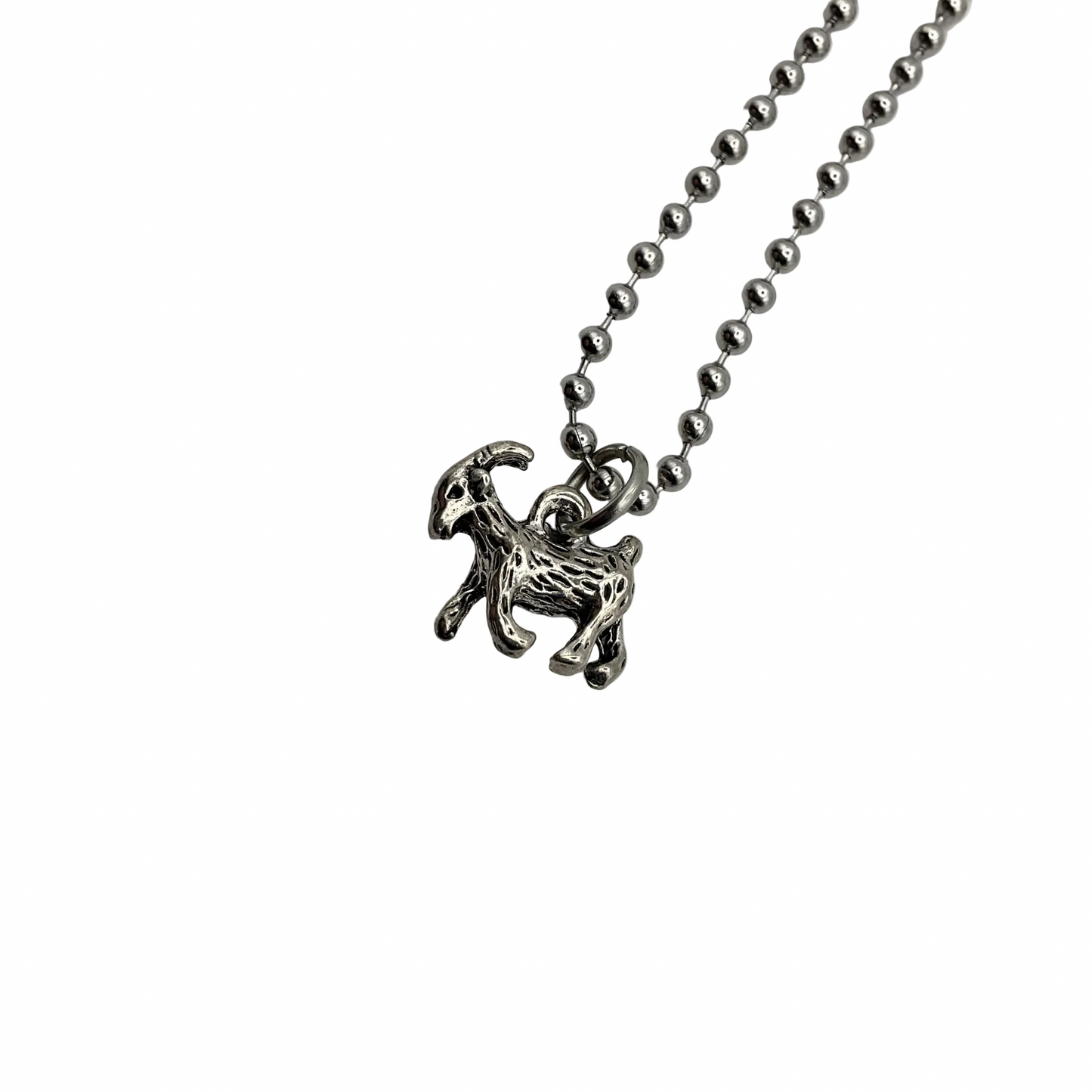 Silver tone goat pendant on a ball chain against a white background