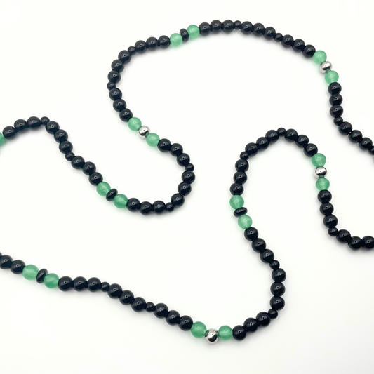 Green Aventurine beaded necklace with black and steel bead accents against a white background.