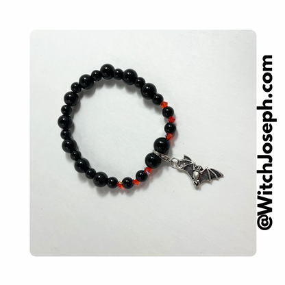 Halloween Bat stretch bracelet with orange and black beads displayed against a light background with the Witch Joseph URL