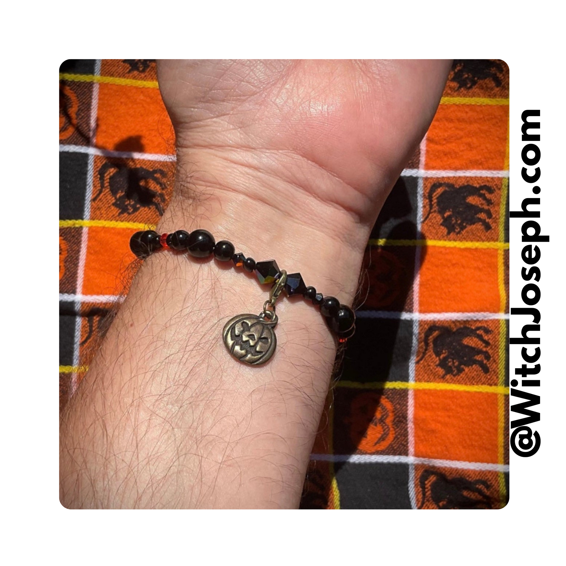 Jack o Lantern stretch bracelet displayed on a models wrist against vintage style halloween fabric