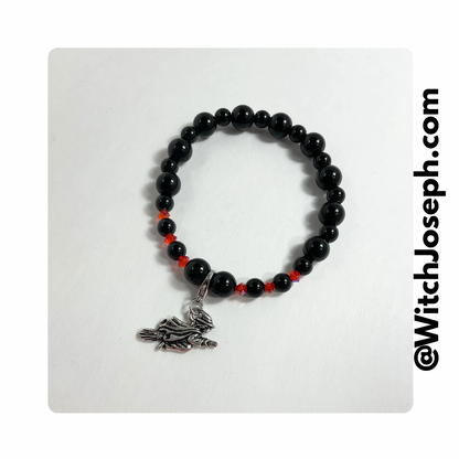 Halloween Witch halloween stretch charm bracelet with black and orange beads displayed against a light background with the Witch Joseph URL