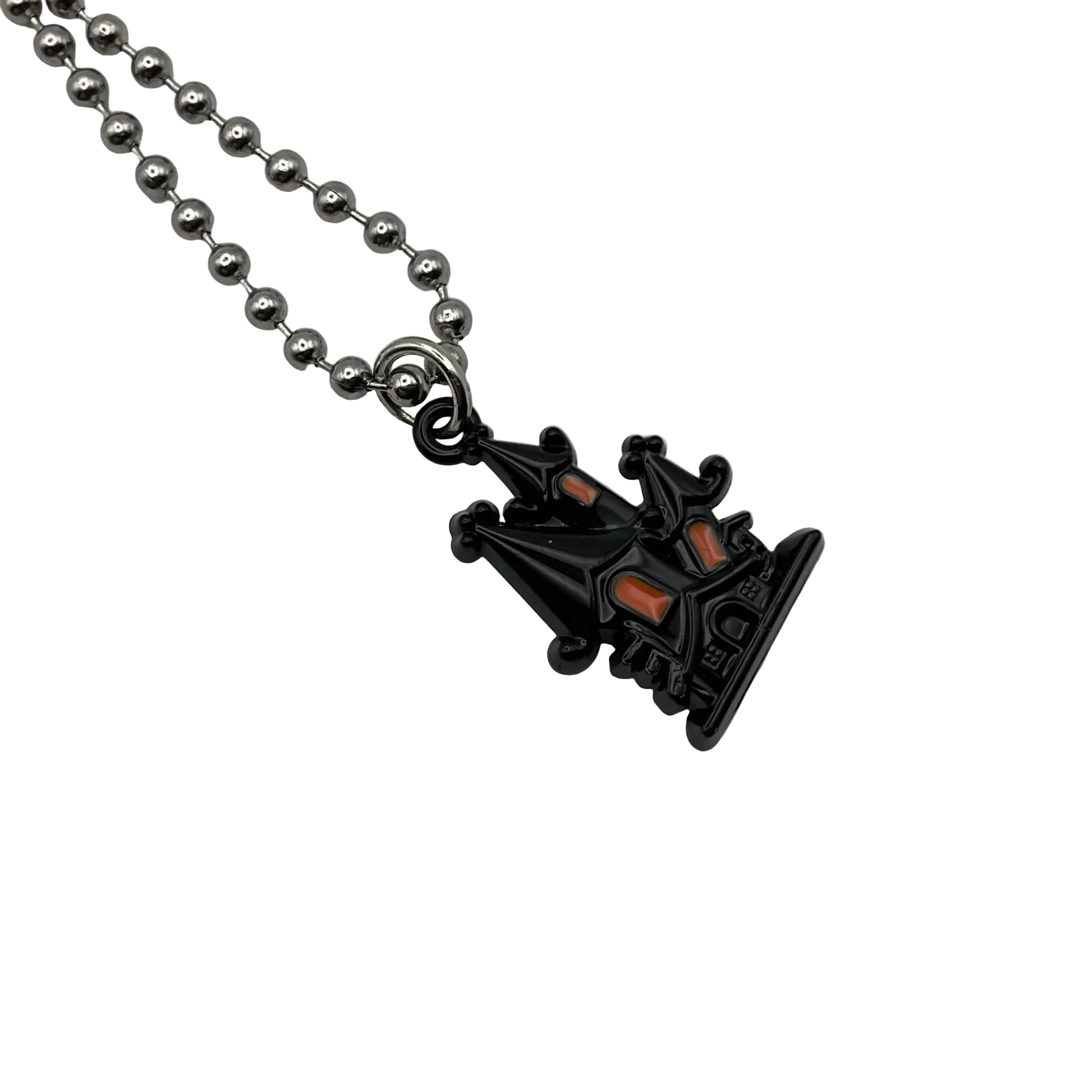 Black Haunted House pendant with orange accents on a silver tone ball chain against a white background