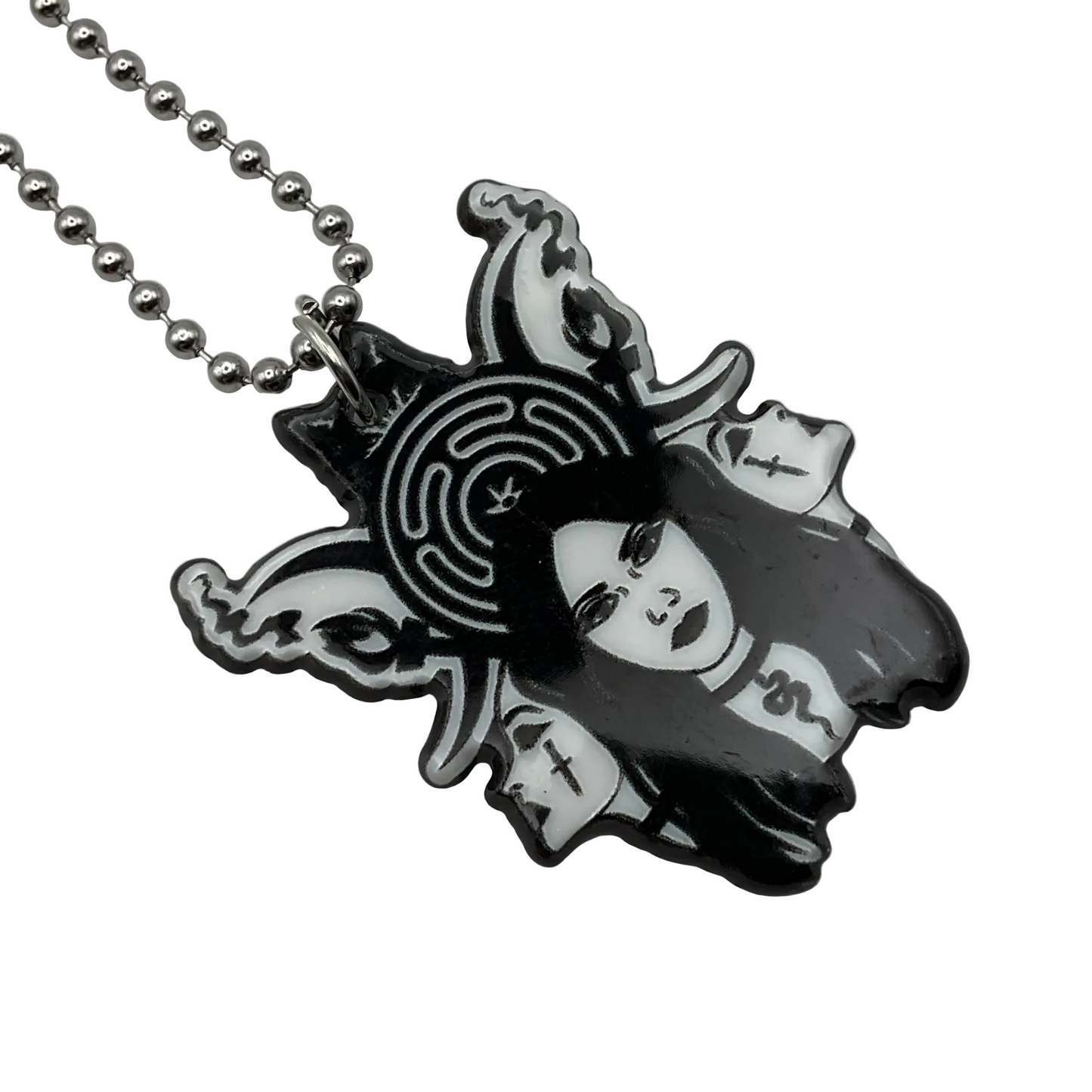 Necklace with an acrylic pendant featuring a stylized triple face of Hekate with the Hekate wheel behind Her design on a white background