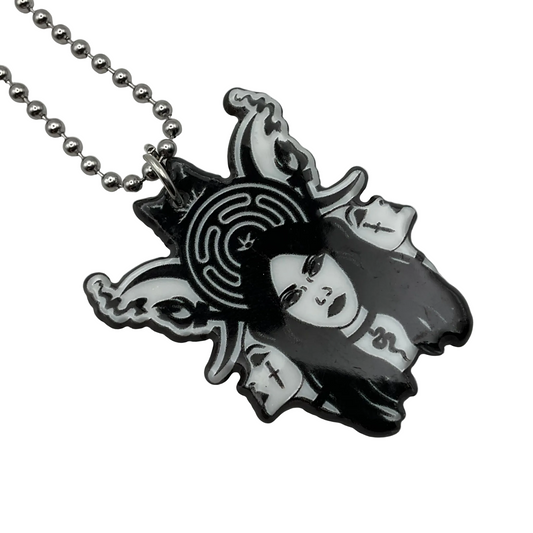 Necklace with an acrylic pendant featuring a stylized triple face of Hekate with the Hekate wheel behind Her design on a white background