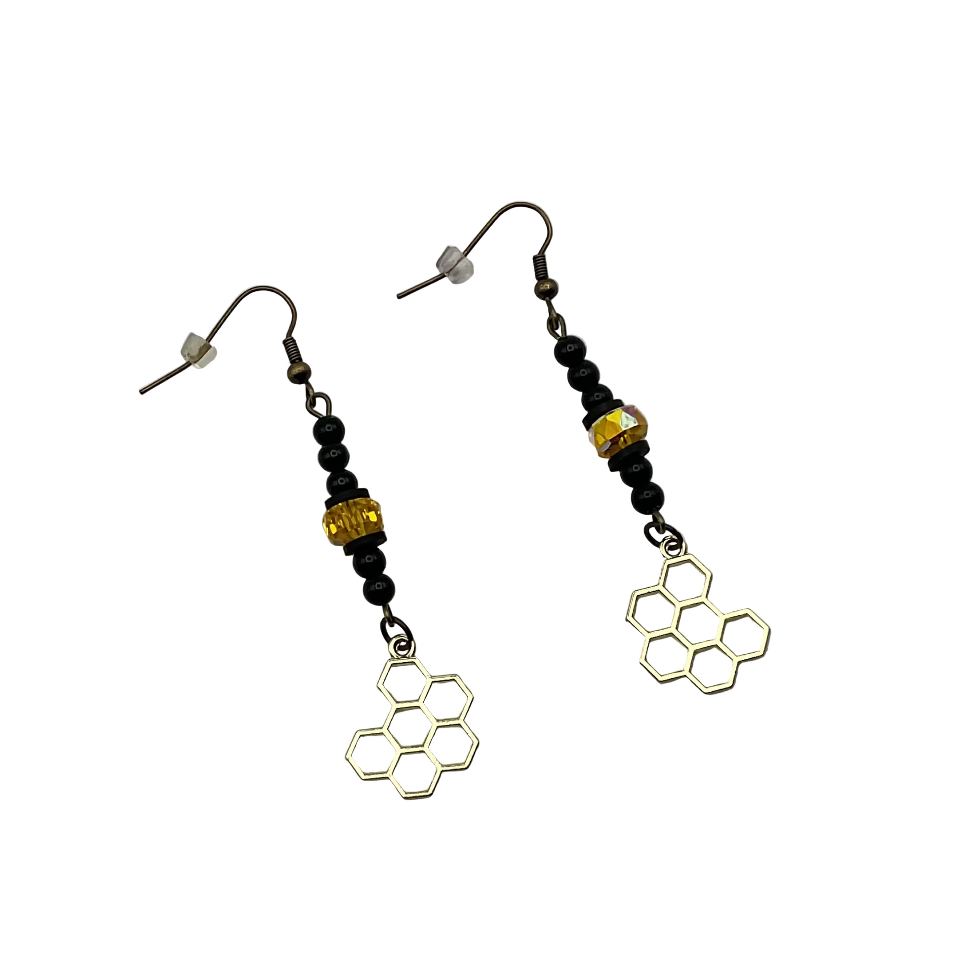 Pair of earrings with dangling honeycomb designs with black beads and a sparkly golden tone crystal bead displayed on a white background