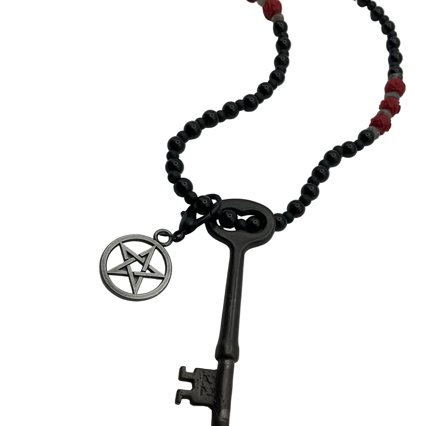 Necklace with black beads and a vintage key pendant with  pentagram charm on a white background