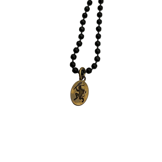Black ball chain necklace with a brass Krampus pendant on a white background